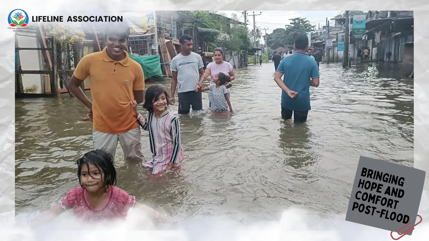 A resident standing in floodwater beside a waterlogged home